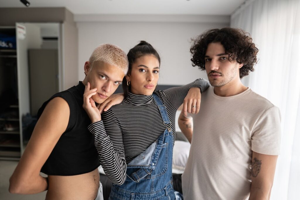 a woman and two men standing together with their arms on each other